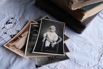 old photo albums lie on a white mint tablecloth, vintage photographs of 1960, concept of family tree, genealogy, childhood memories, connection with ancestors