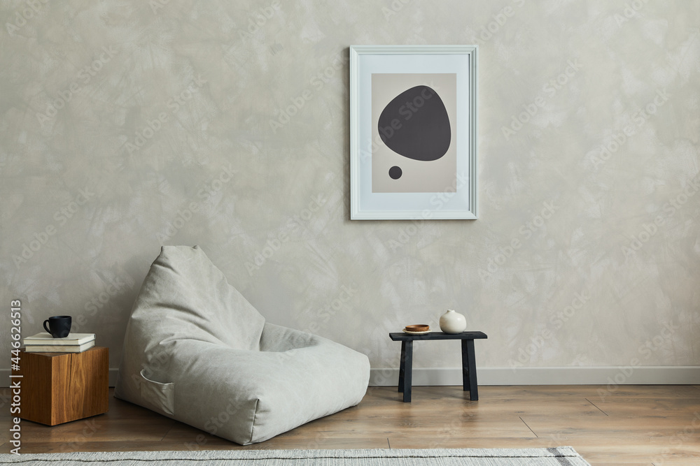 Stylish composition of minimalistic living room interior with mock up poster frame, grey pouf, black tiny coffee table, wooden cube and elegant personal accessories on it. Template. - obrazy, fototapety, plakaty 