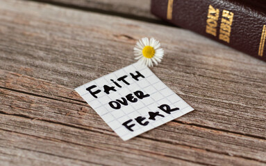 Wall Mural - Faith over fear. Inspiring handwritten quote from the Bible Book. Trust, faith, hope, belief in God and Jesus Christ. Devoted faithful Christian biblical concept. A closeup.