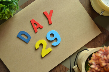 Aufkleber - Day 29, cover design in natural concept with the alphabet on brown notebook on the wooden table for a background.