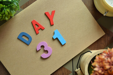 Aufkleber - Day 31, cover design in natural concept with the alphabet on brown notebook on the wooden table for a background.