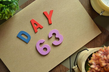 Aufkleber - Day 63, cover design in natural concept with the alphabet on brown notebook on the wooden table for a background.