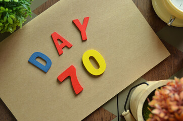Aufkleber - Day 70, cover design in natural concept with the alphabet on brown notebook on the wooden table for a background.
