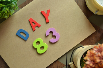 Aufkleber - Day 83, cover design in natural concept with the alphabet on brown notebook on the wooden table for a background.