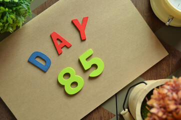 Aufkleber - Day 85, cover design in natural concept with the alphabet on brown notebook on the wooden table for a background.