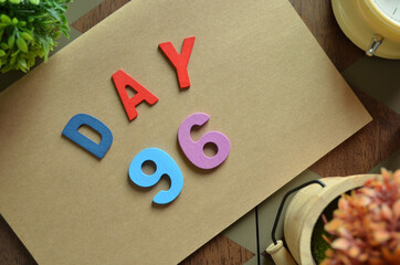 Aufkleber - Day 96, cover design in natural concept with the alphabet on brown notebook on the wooden table for a background.