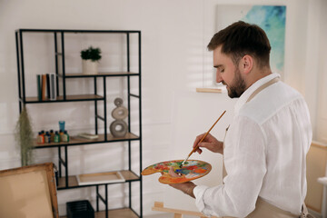 Poster - Young man painting with brush in artist studio