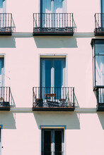Vertical Shot Of Beautiful Symmetrical Balconies On A Clean Building With The Sun Shining On It