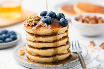 Wall Mural - Syrup pouring over blueberry pancakes. Sweet breakfast food
