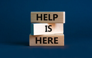 help is here and support symbol. wooden blocks with words 'help is here' on beautiful grey backgroun