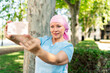 © Cavan Images - woman with cancer taking pictures with her smartphone