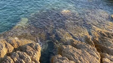 Canvas Print - Beautiful rocky sea coast landscape at summer day. Turquoise blue rippled sea water. Transparent ocean waves. Loneliness. Solitude. Awesome nature of Mediterranean coast. Scenic coastal rocks.