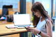 © Prathankarnpap - Asian woman holding credit card and using smart phone for shopping online.