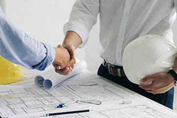 Shaking hands of collaboration, Construction engineering or architect discuss a blueprint while checking information and conference new project plan , contract , success, partnership concept.