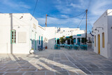 Fototapeta Uliczki - Serifos island, Chora, Cyclades Greece. Open empty cafe tavern chairs tables background.