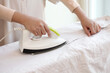 © seksanwangjaisuk - Female hand ironing cotton clothes in home.