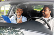 © Syda Productions - driver courses, exam and people concept - happy smiling indian man and driving school instructor with clipboard showing thumbs up in car
