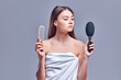 © Olena Apetroaiei - Portrait of a beautiful attractive cute well-groomed lady holding a comb in her hand, smooth, soft, silky hair, keratin effect, isolated on gray background.