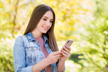 Poster - Portrait of attractive focused cheerful girl spending time using device blogging outdoor strolling fresh open air