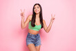 Photo of pretty adorable young lady wear green tank-top showing tow v-signs smiling isolated pink color background