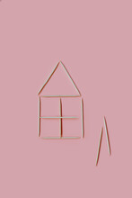 Small House Made Of Wooden Toothpicks On A Pink Background