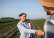 © Budimir Jevtic - Young female insurance sales rep shaking hands with male farmer.