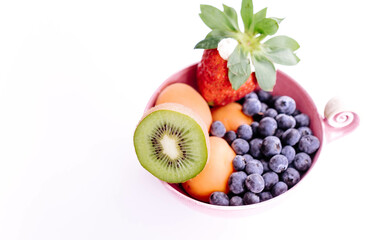 Bowl of fresh fruits and blueberries on a white background