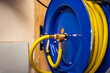 auto-rewinding air hose reel with coiled tubing mounted on a wall in a shop