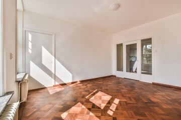 Empty room with white walls and a wooden floor.