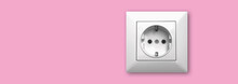 House Electricity And Outlet Concept Background And Banner, EU Electric Socket On A Pink Wall, Copy Space Photo