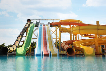 Wall Mural - Beautiful view of water park with colorful slides and swimming pool on sunny day