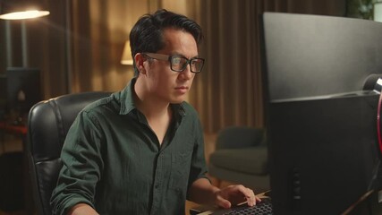 Asian Male Works His Personal Computer. He Works At Night
