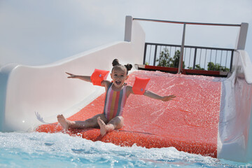 Poster - Cute little girl on slide in water park