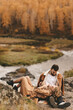 © Елизавета Старкова - Happy cheerful couple in love newlyweds two people in casual clothes travel together hike and walk in the local autumn forest in nature on vacation enjoy the landscape of outdoor activities