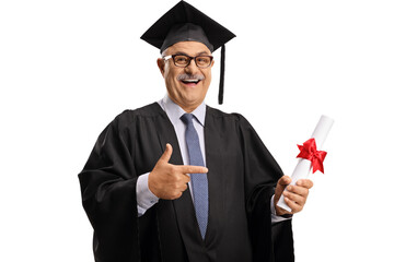 Mature man in a graduation gown holding a diploma and pointing