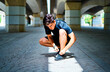 © Cavan Images - Athlete tying his running shoes before running