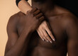 © Cavan Images - Naked chest of African American male holding hand of female at studio