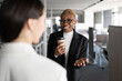 © Cavan Images - Cheerful black businesswoman speaking with colleague