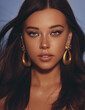 © Cavan Images - Beautiful woman smooth long hair brunette evening make up with liner tanned skin beautiful female portrait over blue background wearing gold earrings