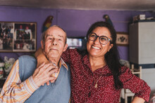 Portrait Of A Middle-aged Daughter And Her Elderly Father Embracing.