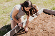 © Cavan Images - Woman plants seedlings in her backyard garden on a warm summer day