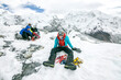 © Cavan Images - A climber sits exhausted after a successful summit on Island Peak