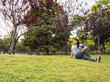 © Cavan Images - young girl doing side stretching on park lawn