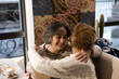 © Cavan Images - Two adult women thank each other, hug and laugh.