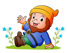 The Cute Dwarf Is Sitting On The Grass And Waving The Hand