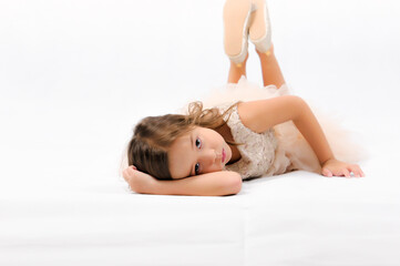portrait of happy pretty curly little girl laying on the floor and posing over white background , ha