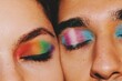 Closeup portrait of queer friends / young couple faces & eyes wearing eyeshadow makeup of lgbtq rainbow pride flag & trans pride flag