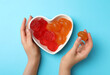 © New Africa - Woman with delicious gummy candies on light blue background, top view