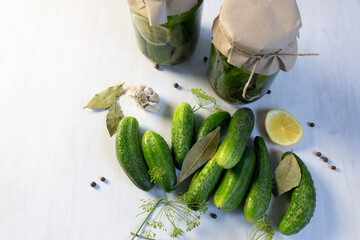 Wall Mural - Cooking preserve in Glass jar with fermented cucumbers with lemon, herbs, spices on white background