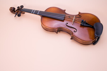 Sticker - Closeup shot of a violin isolated on a pink background